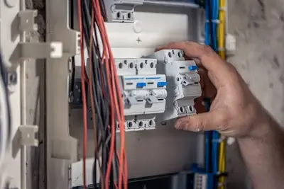 Elettricista durante un intervento sul quadro elettrico a Bologna